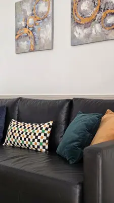 a black leather couch with two pillows on it at Las Artes Hlius Luxury Apartments in Valencia