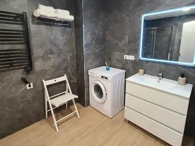 a bathroom with a washing machine and a sink at Las Artes Hlius Luxury Apartments in Valencia
