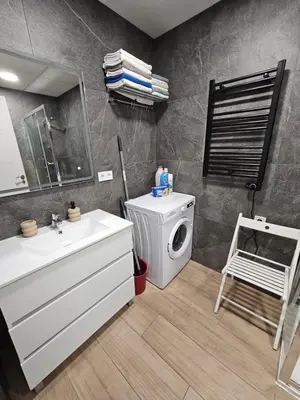 a bathroom with a sink and a washing machine at Las Artes Hlius Luxury Apartments in Valencia