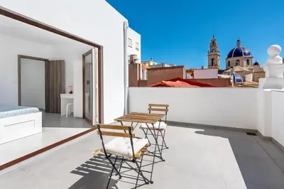 a balcony with two chairs and a table on a building at Vilamercat in Sueca