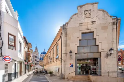 an old building on a street in a city at Vilamercat in Sueca
