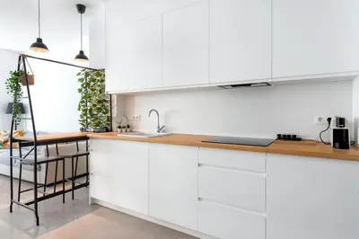 a kitchen with white cabinets and a sink at Vilamercat in Sueca