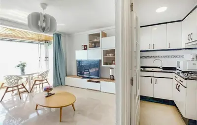 a kitchen with white cabinets and a table in a room at 1 Bedroom Nice Apartment In Cullera in Cullera