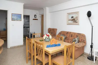 a dining room with a table and a couch at Solimar, 4-8 in Cullera