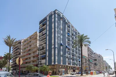 a tall building on a city street with palm trees at Solimar, 4-8 in Cullera