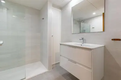 a white bathroom with a sink and a shower at ApartUP Patacona Surfing Beach in Valencia