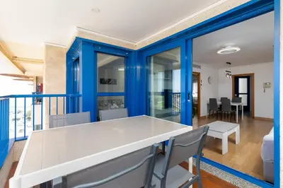 a dining room with blue walls and a white table and chairs at ApartUP Patacona Surfing Beach in Valencia