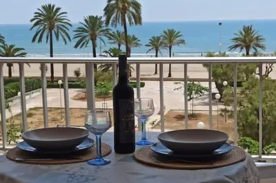 a table with a bottle of wine and two glasses at El Cisne frente al mar- Piscina y Wifi in Cullera