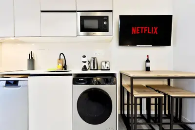 a kitchen with a washing machine and a table at Apartamentos Río Turia in Valencia