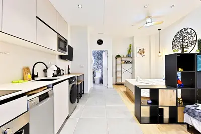 a kitchen with white cabinets and a counter top at Apartamentos Río Turia in Valencia