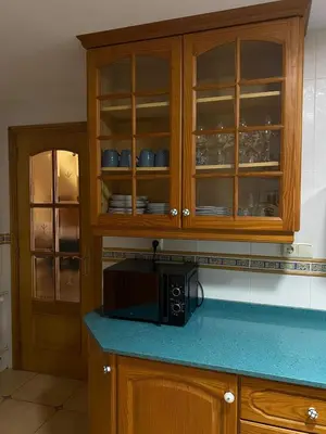 a kitchen with wooden cabinets and a microwave at Casa Rural Roa in Casinos