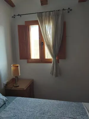 a bedroom with a window and a bed and a lamp at Candela de la Murtera in Chelva