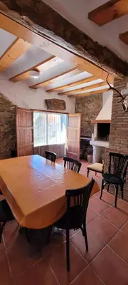 a dining room with a large wooden table and chairs at Candela de la Murtera in Chelva