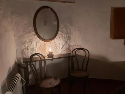 a table with two chairs and a mirror on a wall at Candela de la Murtera in Chelva