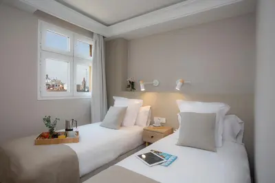 a hotel room with two beds and a window at SingularStays Ático Reina Catalina in Valencia