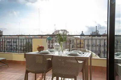 a table on a balcony with a view of a city at SingularStays Ático Reina Catalina in Valencia