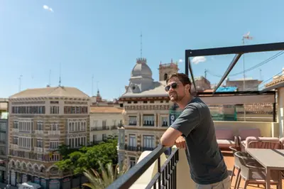 a man standing on a balcony overlooking a city at SingularStays Ático Reina Catalina in Valencia