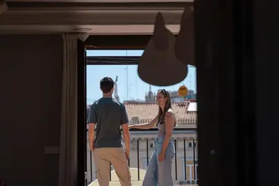 a man and a woman looking out of a door at SingularStays Ático Reina Catalina in Valencia