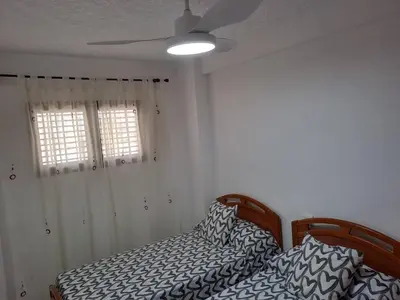 a bedroom with a bed and a ceiling fan at Cullera apartamento junto al mar in Cullera