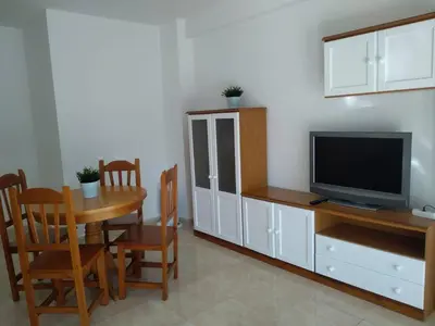 a living room with a television and a table and chairs at Cullera apartamento junto al mar in Cullera