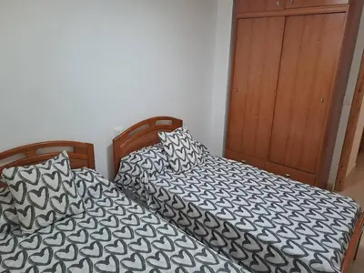 two beds sitting next to each other in a bedroom at Cullera apartamento junto al mar in Cullera