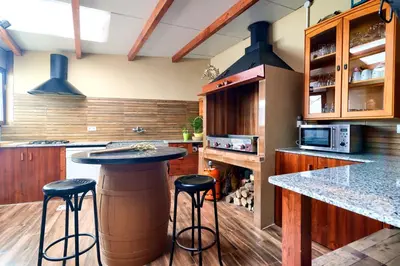 a kitchen with a bar with stools in it at Cueva con jacuzzi a 20 minutos de Valencia in Benaguacil