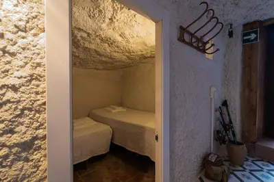 a small bedroom with a small bed in a room at Cueva con jacuzzi a 20 minutos de Valencia in Benaguacil