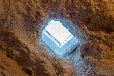 a window in a rock wall with a window in it at Cueva con jacuzzi a 20 minutos de Valencia in Benaguacil