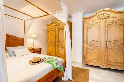 a bedroom with a canopy bed and a wooden cabinet at Casa para familias y grupos in Manises