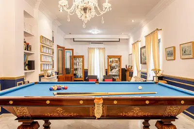 a living room with a pool table and a chandelier at Casa para familias y grupos in Manises