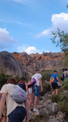 a group of people walking down a rocky trail at Refugio La Presa in Chulilla