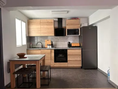 a kitchen with a table and a black refrigerator at Apartamento Horizonte Azul Cullera in Cullera