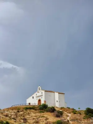 an old white building on top of a hill at Apartamento Horizonte Azul Cullera in Cullera