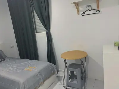 a bedroom with a bed and a table next to a window at Your Perfectt place in Valencia