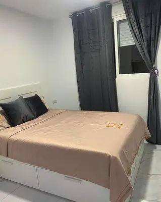 a bedroom with a large bed with black curtains at Your Perfectt place in Valencia