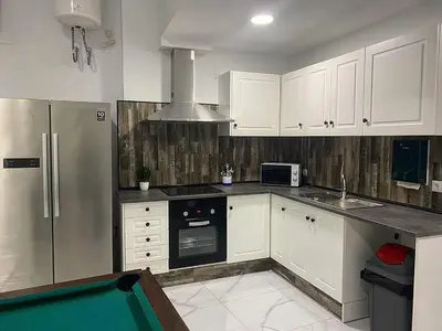 a kitchen with white cabinets and a pool in it at Your Perfectt place in Valencia