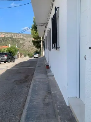 an empty street next to a white building at DeCASTA in Chulilla