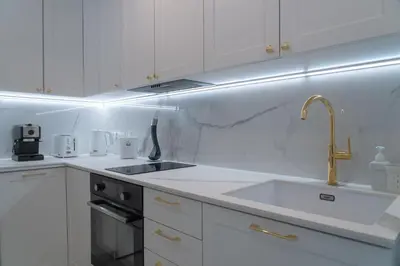a kitchen with white cabinets and a sink at Apartamento mar&menta in Cullera