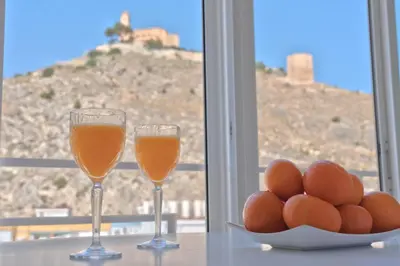 two glasses of orange juice and eggs on a table at Apartamento mar&menta in Cullera