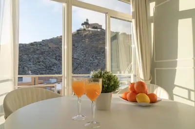 a table with two glasses of orange juice and a bowl of fruit at Apartamento mar&menta in Cullera