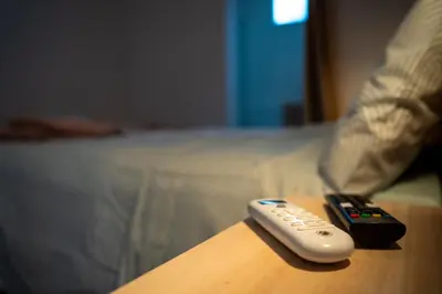 two remote controls sitting on a table next to a bed at La Siesta Hostel in Almarda