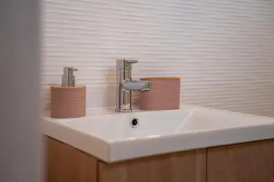 a bathroom sink with two cups on top of it at La Siesta Hostel in Almarda