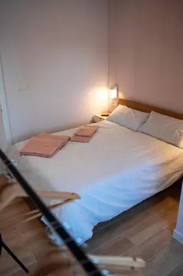a bedroom with a bed with two towels on it at La Siesta Hostel in Almarda