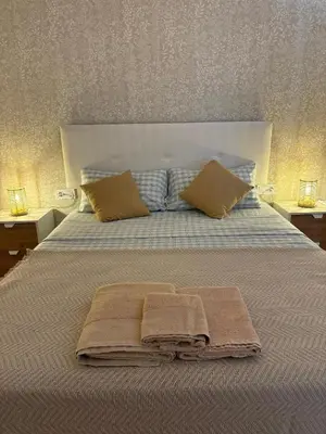 a bed with two pillows and towels on it at La Siesta Hostel in Almarda