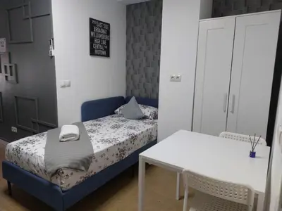 a small bedroom with a bed and a table at Optimus Comfort in Valencia