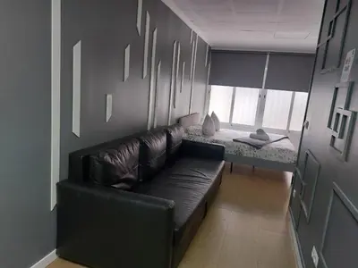 a black leather couch in a room with a table at Optimus Comfort in Valencia