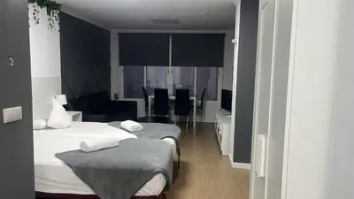 a room with three beds and a living room with a table at Optimus Comfort in Valencia