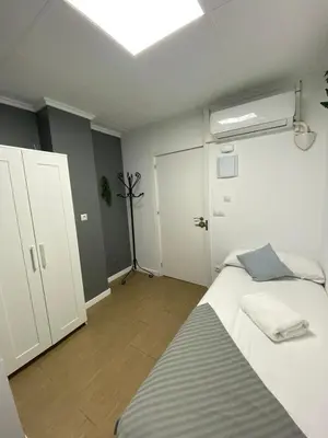 a white bedroom with a bed and a closet at Optimus Comfort in Valencia