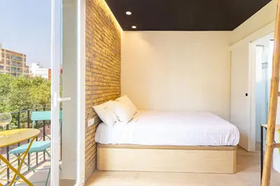 a small bedroom with a bed on a balcony at Private room Beach Valencia in Valencia