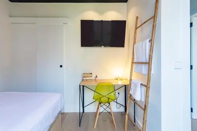 a bedroom with a desk with a yellow chair and a ladder at Private room Beach Valencia in Valencia